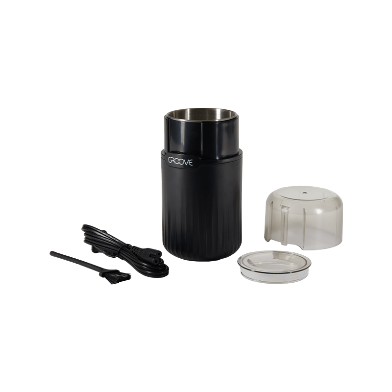 User pressing the button to grind dry herbs in the Groove Ripster electric grinder