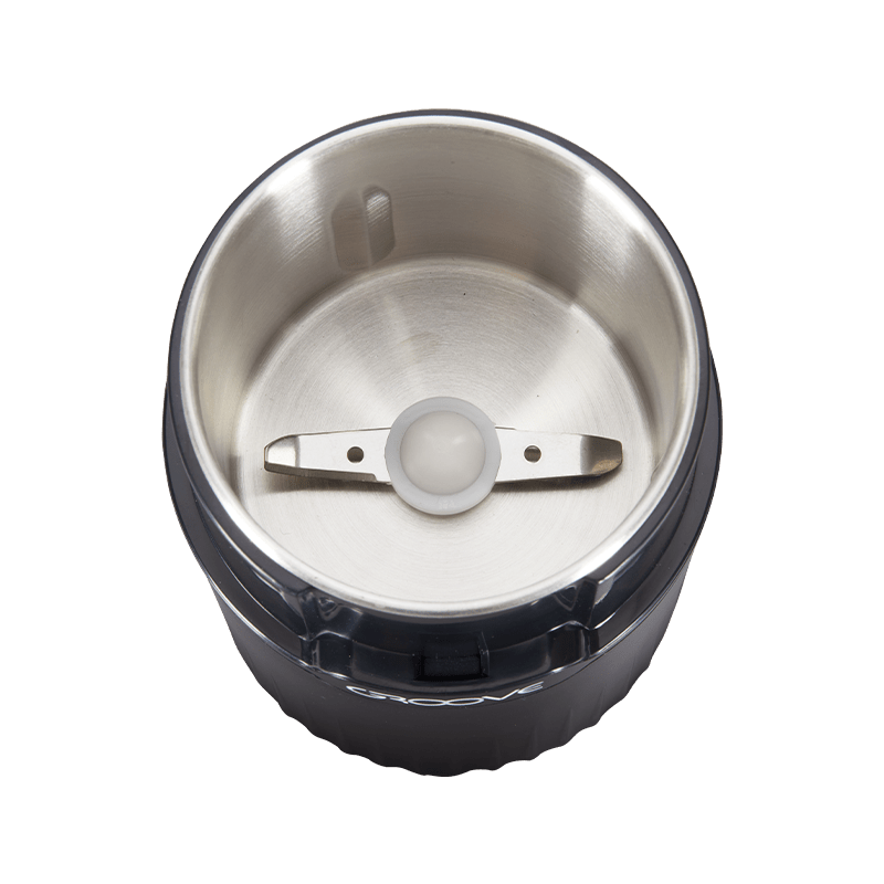User pressing the button to grind dry herbs in the Groove Ripster electric grinder