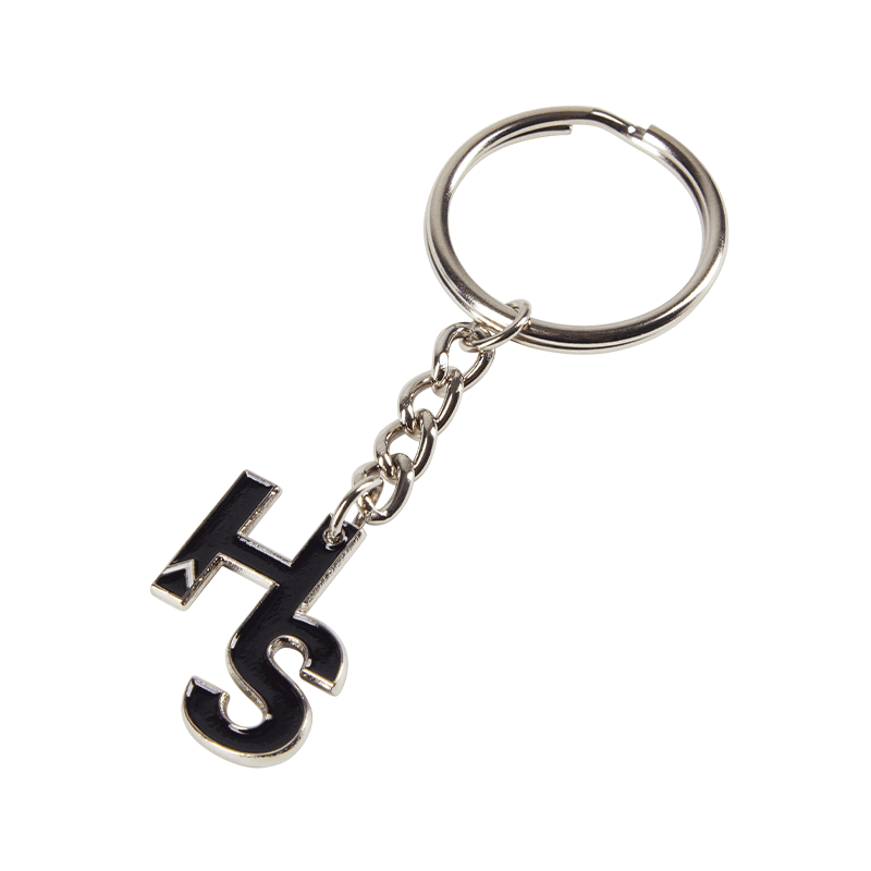 Close-up of a metal logo keychain with engraved branding, showing detailed craftsmanship