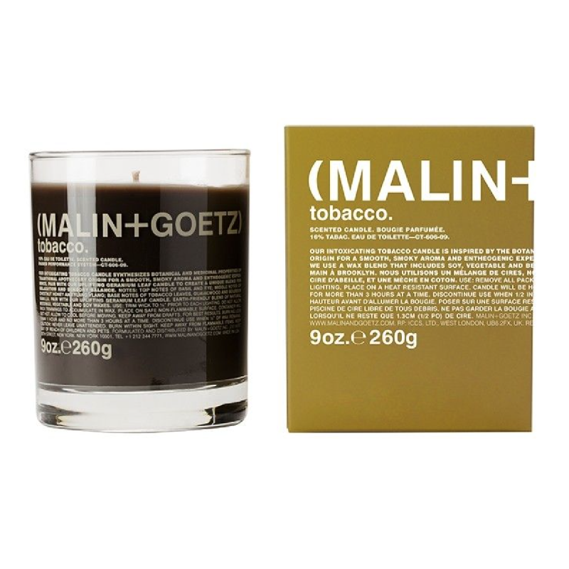 Close-up of Malin + Goetz candle in dark rum scent with warm glow